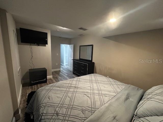 bedroom with dark wood-type flooring