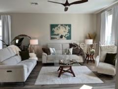 living room featuring dark hardwood / wood-style floors and ceiling fan