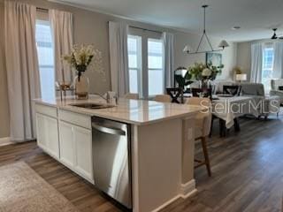 kitchen featuring dishwasher, white cabinets, an island with sink, decorative light fixtures, and dark hardwood / wood-style flooring