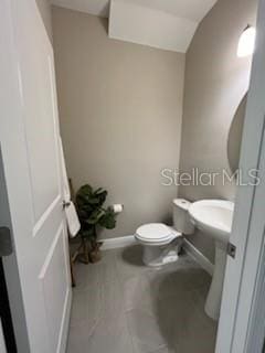 bathroom with lofted ceiling and toilet