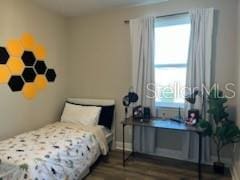 bedroom featuring dark hardwood / wood-style floors and multiple windows