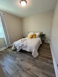 bedroom with dark hardwood / wood-style floors