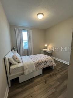 bedroom with dark wood-type flooring