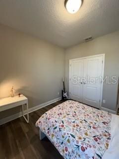 bedroom featuring dark hardwood / wood-style flooring and a closet