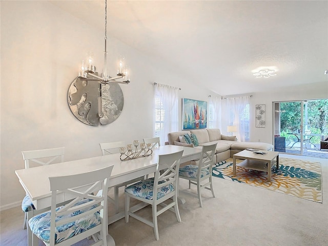 dining room with light colored carpet, vaulted ceiling, and a notable chandelier