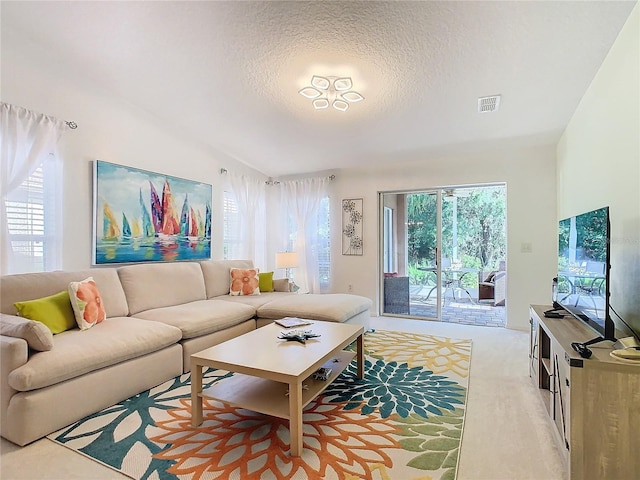 living room featuring light colored carpet and a textured ceiling