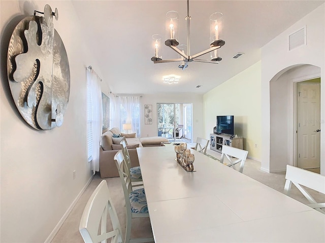 dining space with light colored carpet and an inviting chandelier