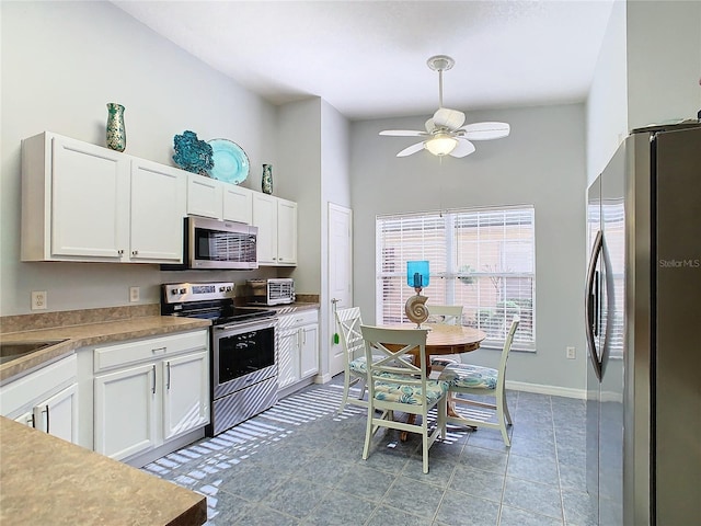 kitchen featuring ceiling fan, white cabinets, high vaulted ceiling, and appliances with stainless steel finishes