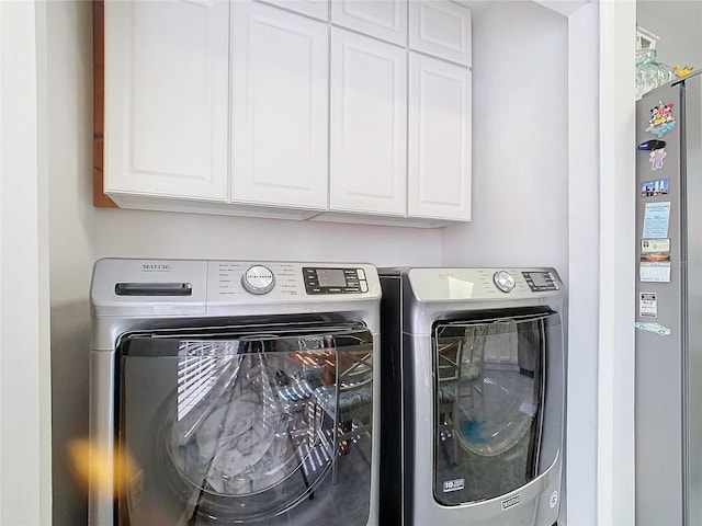 laundry room with washer and dryer and cabinets