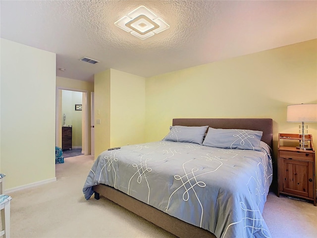 bedroom featuring a textured ceiling and light carpet