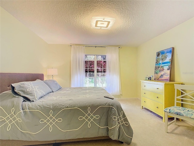 bedroom with a textured ceiling and light colored carpet