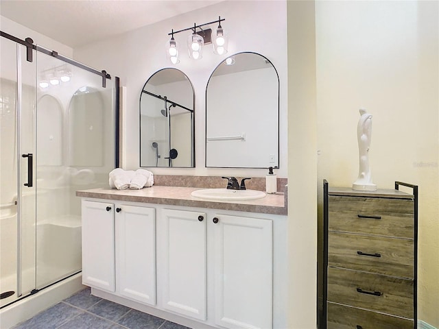 bathroom with tile patterned flooring, vanity, and a shower with shower door