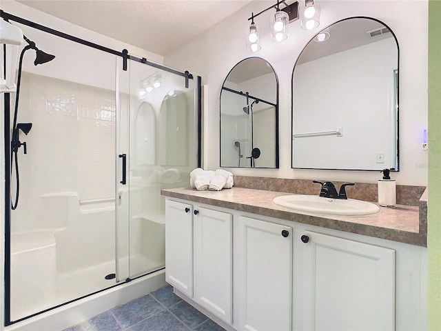 bathroom with tile patterned flooring, vanity, and walk in shower