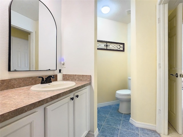 bathroom with tile patterned flooring, vanity, and toilet