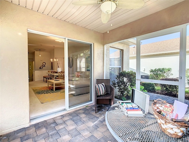 sunroom / solarium featuring ceiling fan and wood ceiling