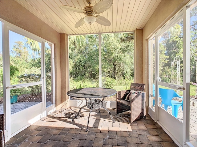 sunroom featuring plenty of natural light, ceiling fan, and wooden ceiling