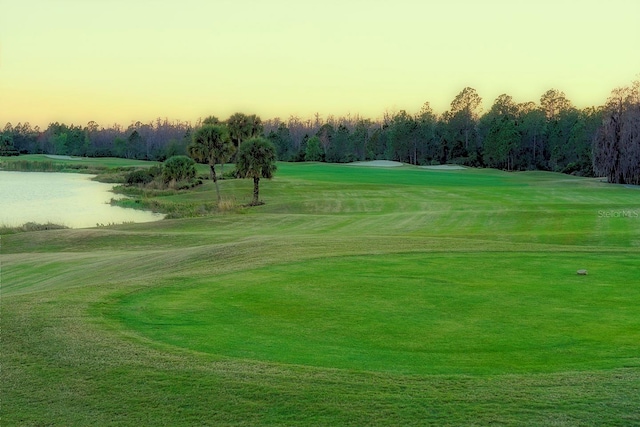 surrounding community with a water view and a lawn