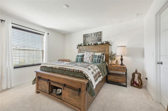 bedroom with a textured ceiling and light colored carpet