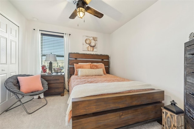 bedroom with light carpet, a closet, lofted ceiling, and ceiling fan