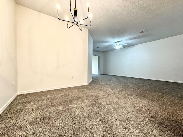 unfurnished room with dark colored carpet, ceiling fan with notable chandelier, and a textured ceiling