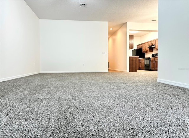 unfurnished living room featuring carpet flooring and a textured ceiling