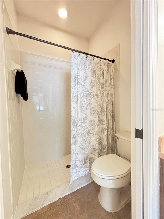 bathroom with toilet, tile patterned floors, and walk in shower