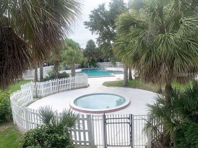 view of pool featuring a patio area and a community hot tub