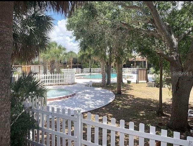 exterior space featuring a pool with hot tub