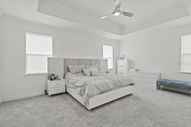 bedroom featuring a tray ceiling, ceiling fan, light colored carpet, and ornamental molding