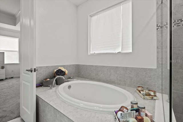 bathroom featuring ornamental molding and tiled bath