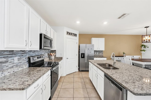 kitchen featuring sink, stainless steel appliances, and an island with sink