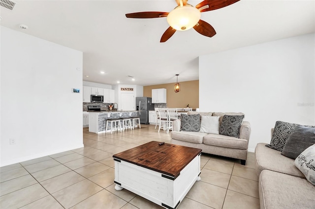 living room featuring light tile patterned floors and ceiling fan