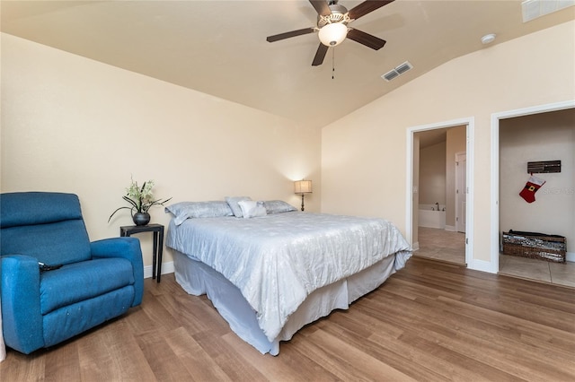 bedroom with ceiling fan, hardwood / wood-style floors, and vaulted ceiling