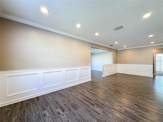 spare room with dark hardwood / wood-style floors, ornamental molding, and a textured ceiling