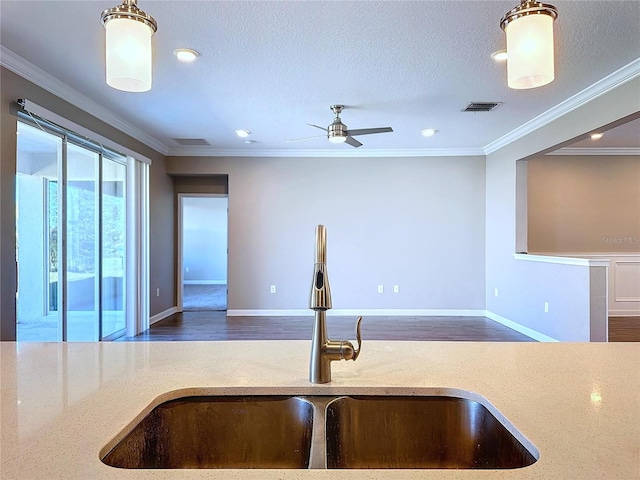 kitchen featuring a textured ceiling, ceiling fan, crown molding, and sink