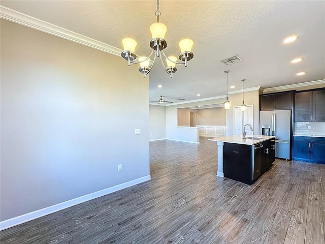 kitchen featuring stainless steel refrigerator with ice dispenser, ceiling fan with notable chandelier, a kitchen island with sink, sink, and pendant lighting