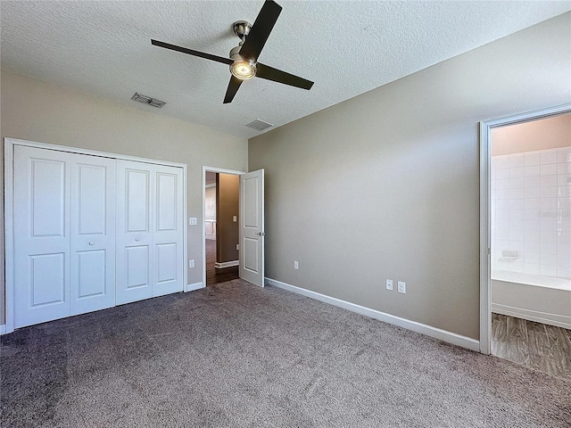 unfurnished bedroom with ceiling fan, dark carpet, a textured ceiling, and a closet