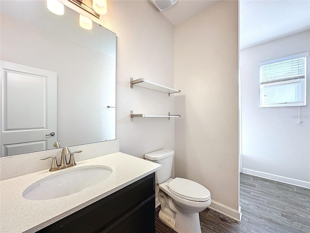 bathroom featuring wood-type flooring, vanity, and toilet