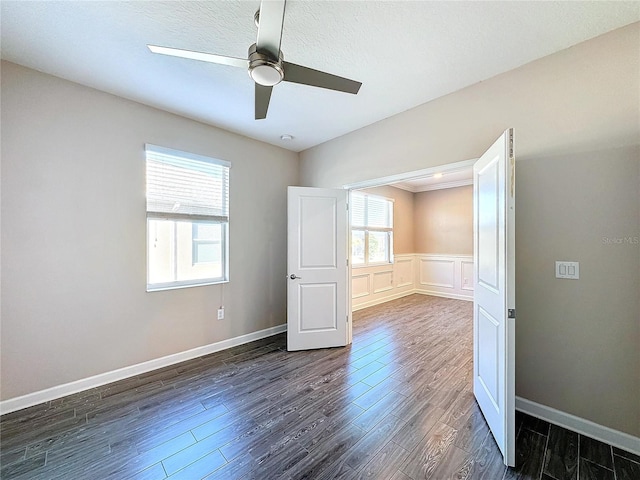 unfurnished room with dark hardwood / wood-style floors, ceiling fan, and ornamental molding