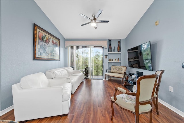 living room featuring ceiling fan, built in shelves, dark wood-type flooring, and vaulted ceiling