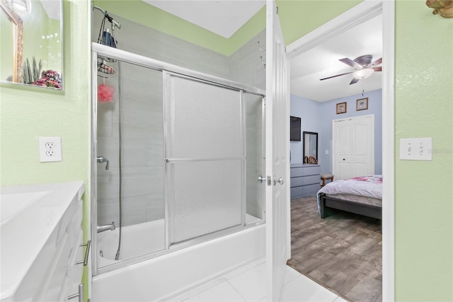 bathroom featuring hardwood / wood-style flooring, ceiling fan, and enclosed tub / shower combo