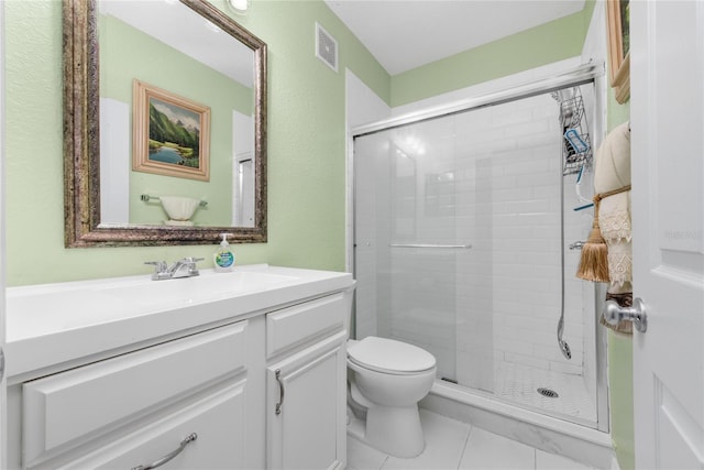 bathroom with tile patterned flooring, vanity, toilet, and a shower with shower door