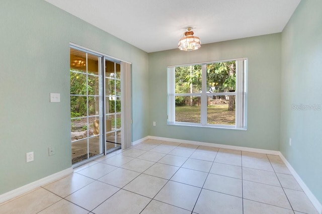 unfurnished dining area featuring an inviting chandelier, plenty of natural light, and light tile patterned flooring