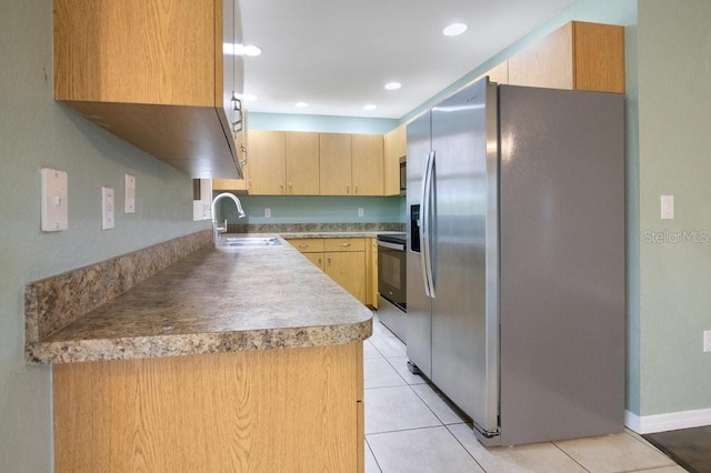 kitchen featuring light brown cabinetry, sink, light tile patterned flooring, and appliances with stainless steel finishes