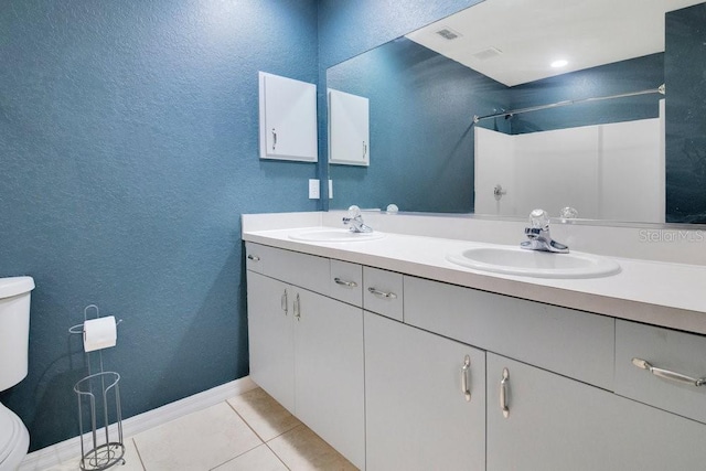 bathroom featuring tile patterned flooring, a shower, vanity, and toilet