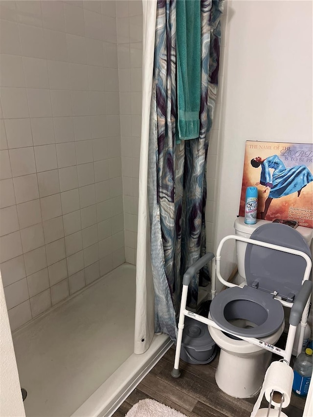 bathroom featuring hardwood / wood-style flooring, toilet, and walk in shower