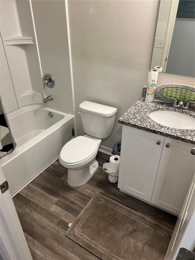 full bathroom featuring hardwood / wood-style floors, vanity, toilet, and tub / shower combination