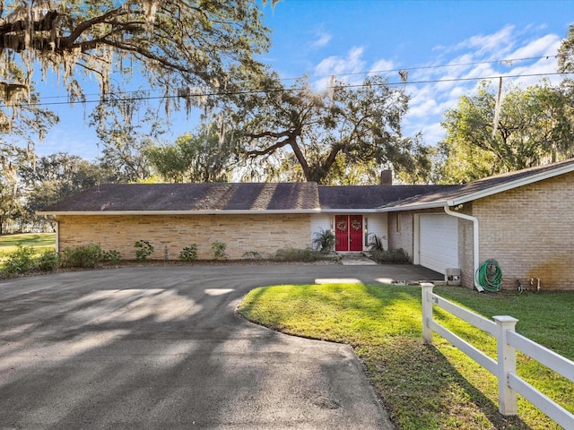 ranch-style home with a front lawn and a garage