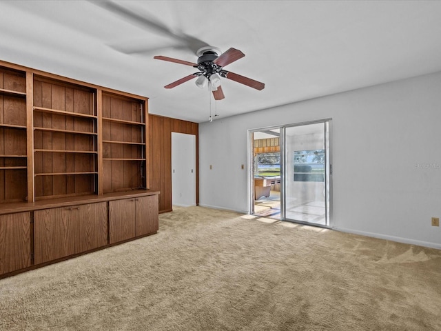 unfurnished living room featuring ceiling fan and light carpet