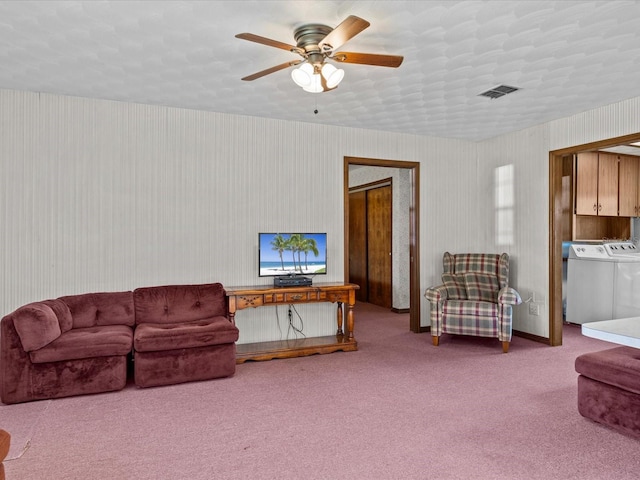 carpeted living room with ceiling fan and washing machine and dryer